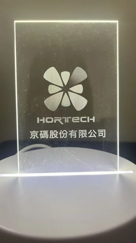 أنماط النقش بالليزر غير المرئية على الأكريليك المتحكم في الضوء - تستخدم هورتيك تقنية النقش بالليزر لإنشاء شعارها على لوحة رقيقة وشفافة.